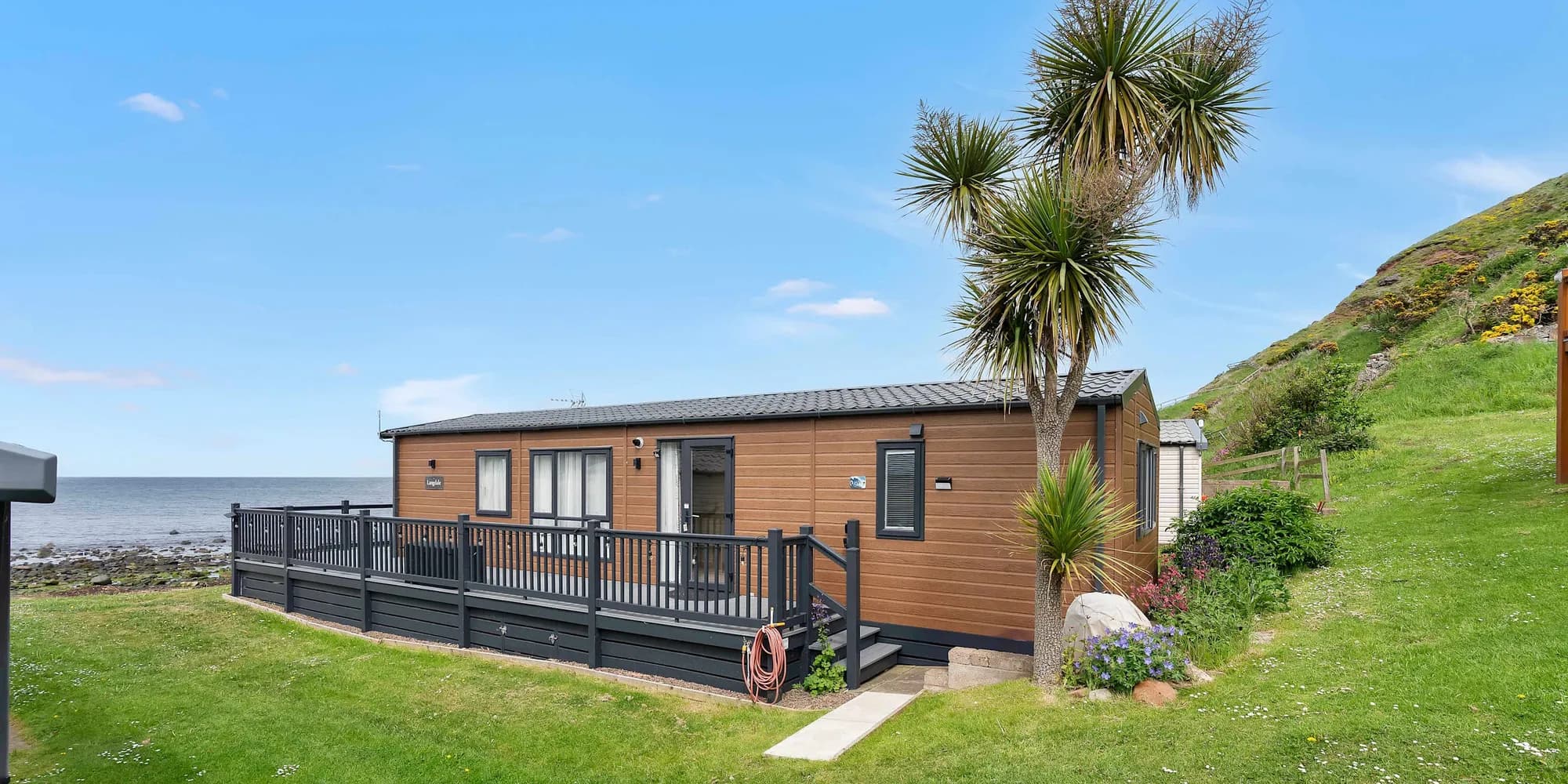 ViVi Stays holiday lodge with a wraparound deck beside the sea on the Scottish coast
